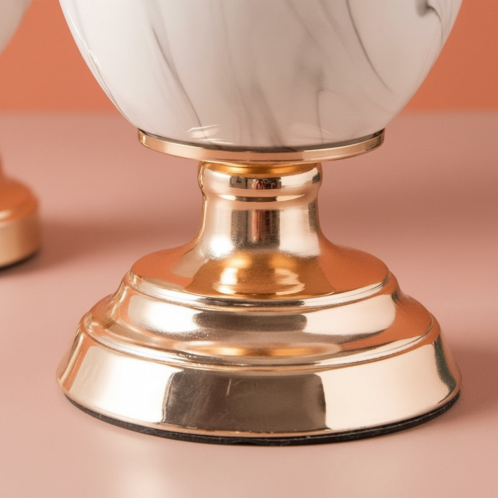 Polished gold-tone pedestal base detail of marble pattern ceramic vase