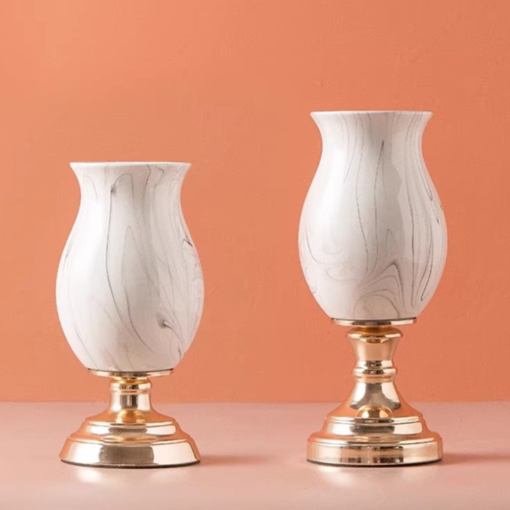 Short and tall marble pattern ceramic pedestal vases displayed side by side