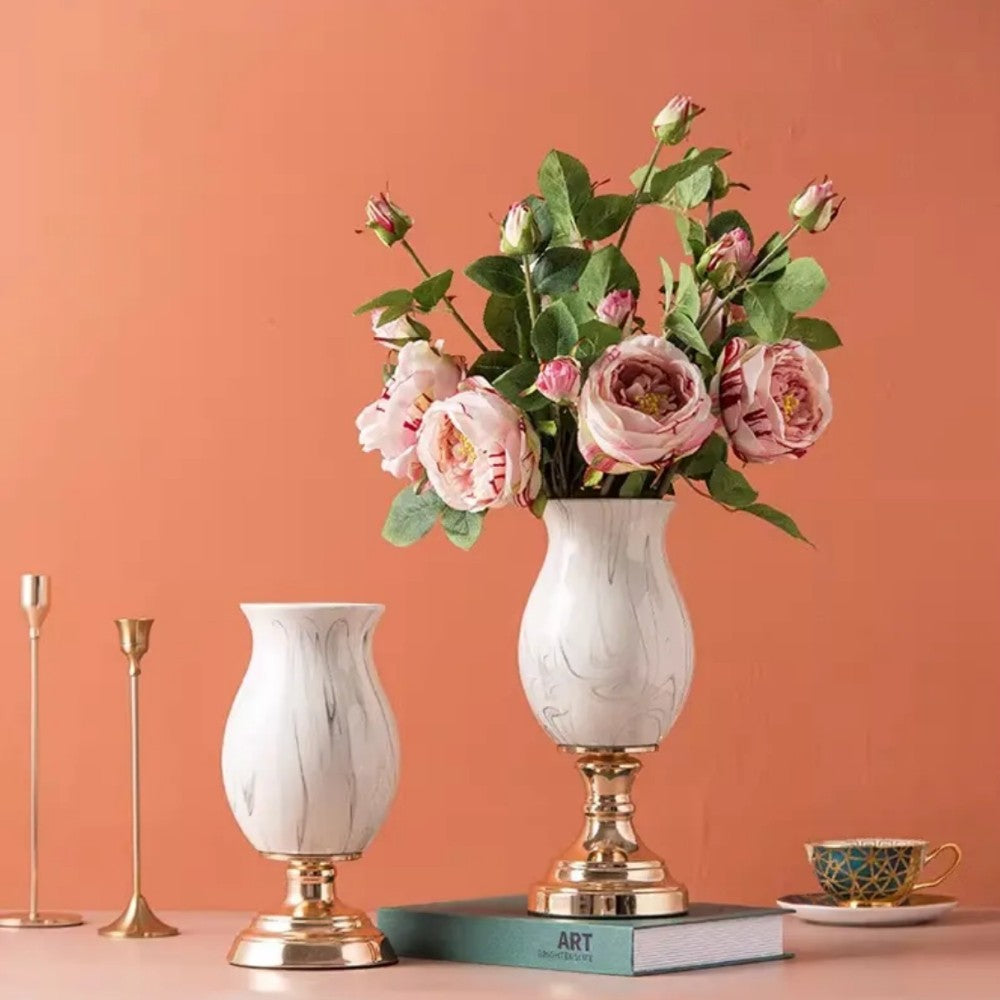 Short and tall ceramic pedestal vases styled with pink flowers and candles