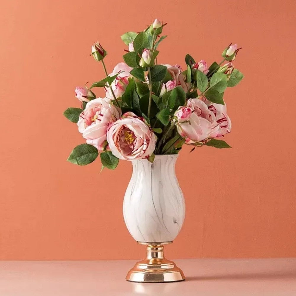 Tall marble pattern ceramic vase with pink floral arrangement on gold pedestal