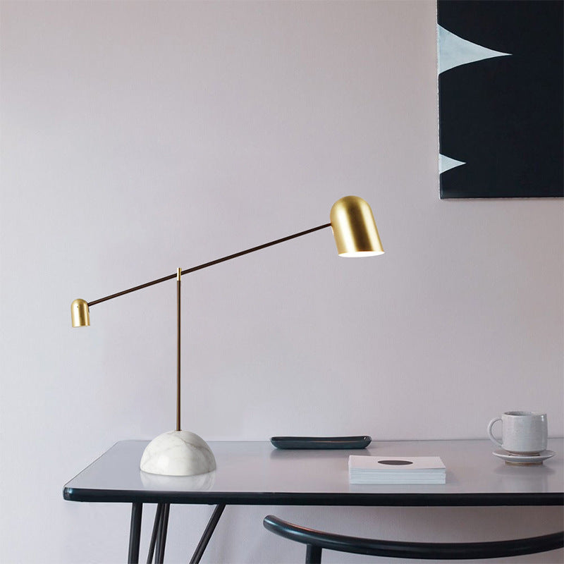 Marble base and brass balance arm lamp on modern desk