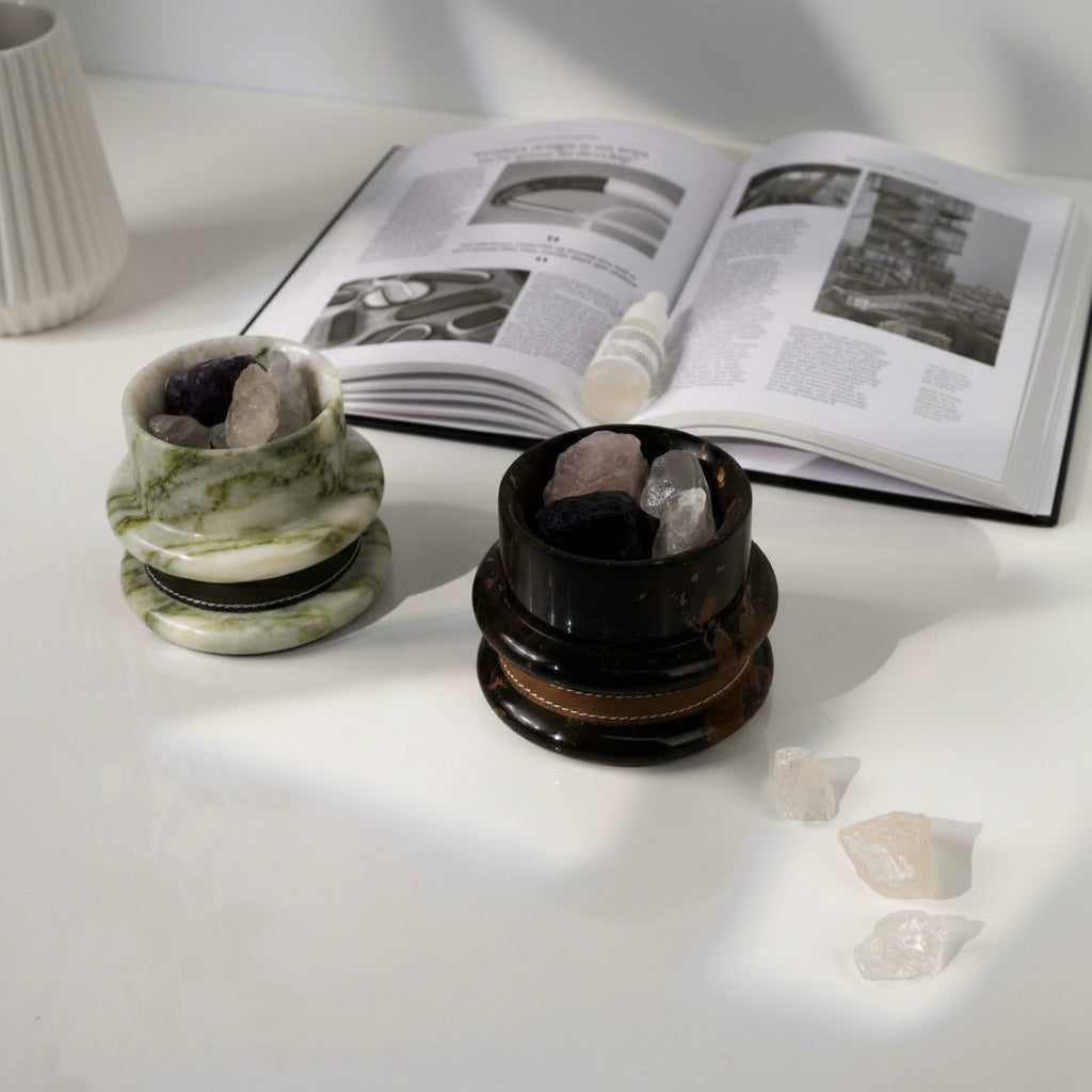 Marble and leather aromatherapy diffusers with raw crystals on white desk