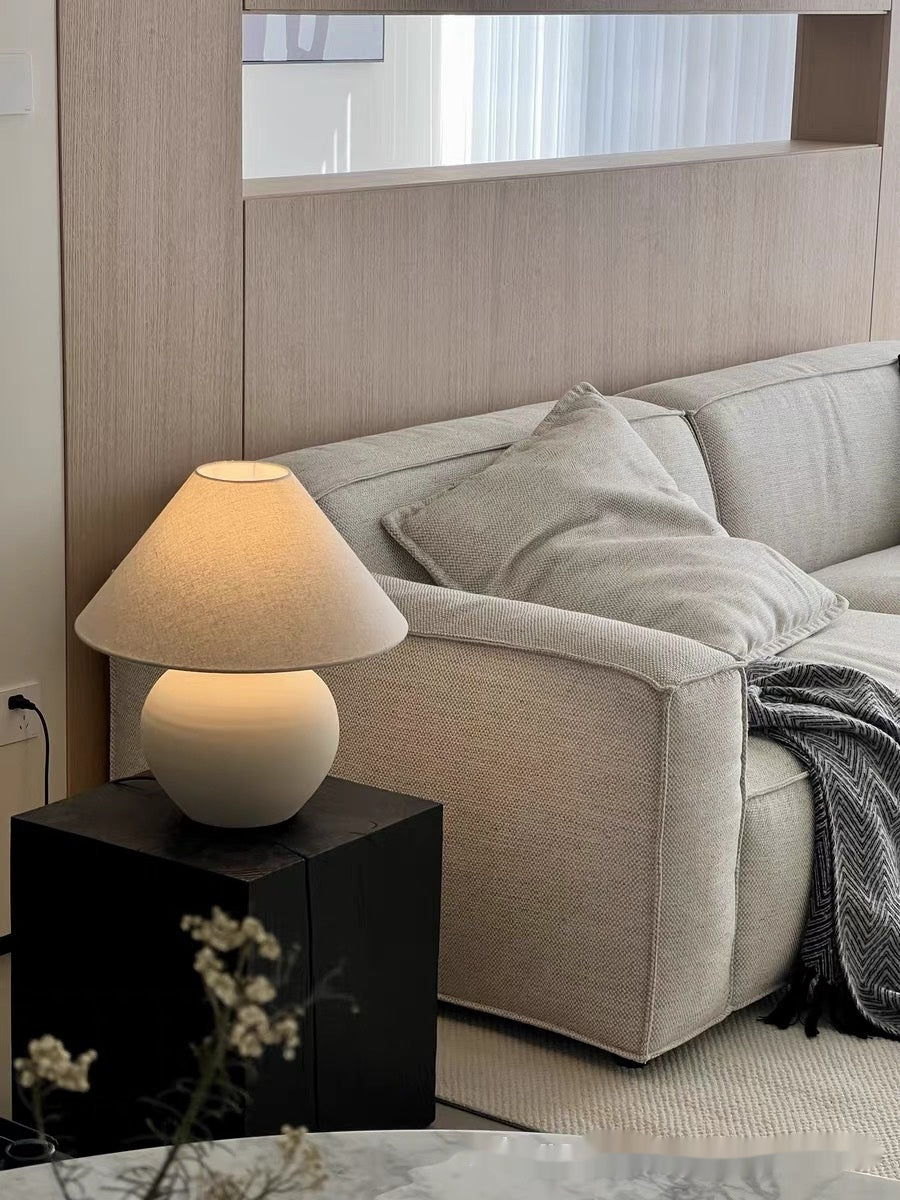 Ceramic table lamp on a side table next to a beige sofa