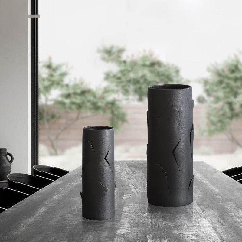 Set of two matte black geometric vases on table