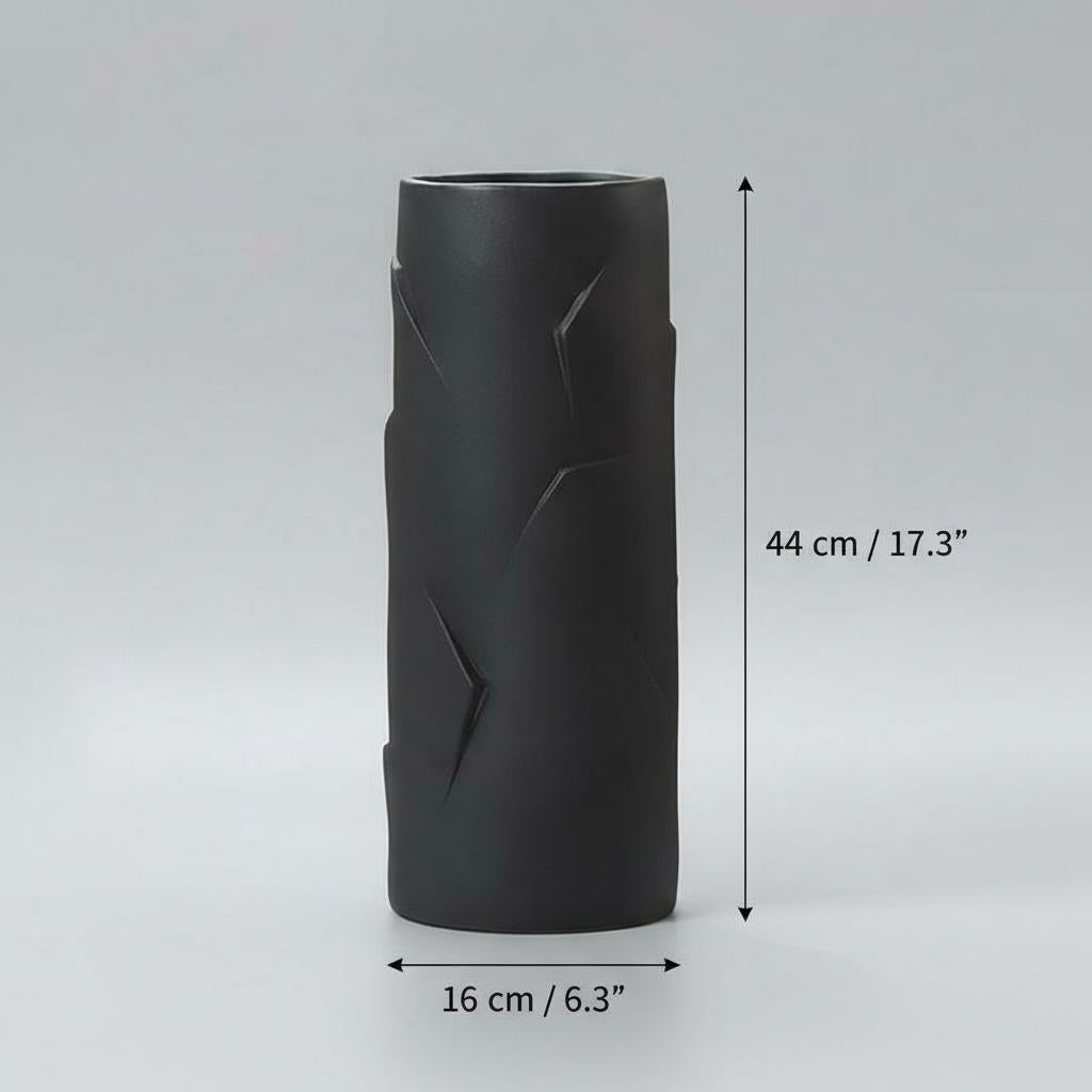 Detail view of faceted texture on black ceramic cylinder vase