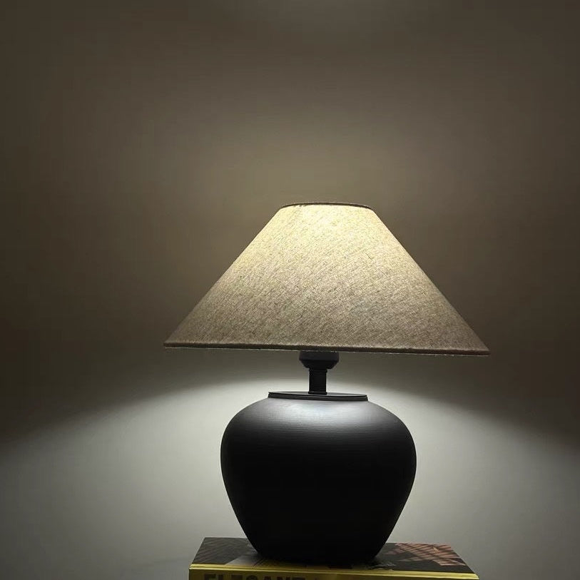 Side view of black ceramic lamp with linen shade