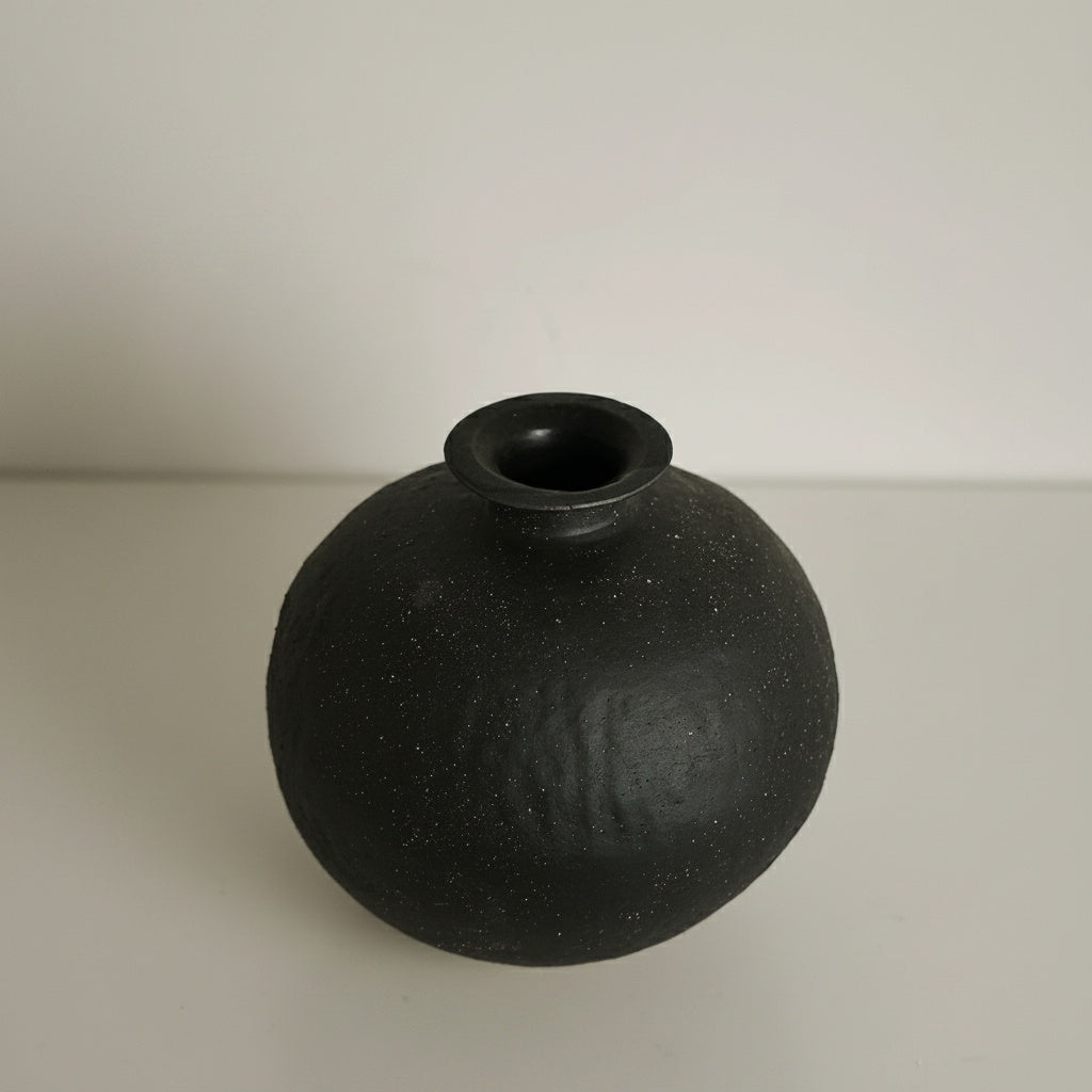 Angled view of matte black ceramic spherical vase