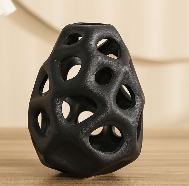 Close up detail of black matte ceramic hollow vase