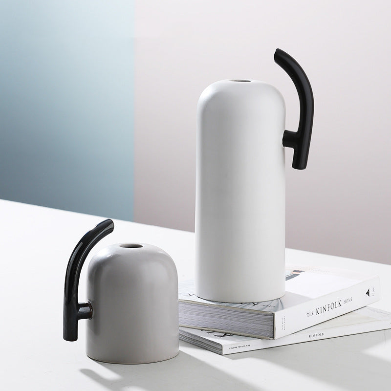 Tall white ceramic vase with black handle