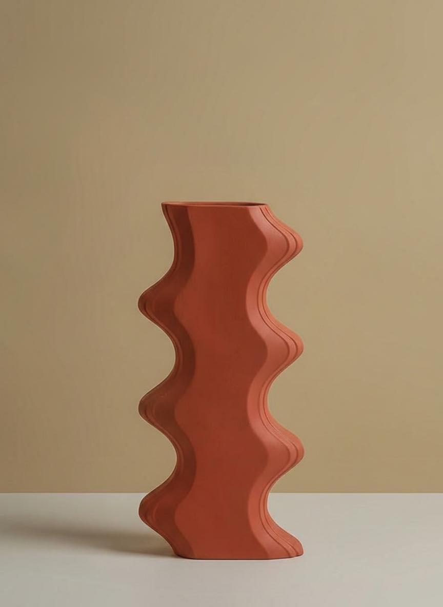 Side profile of tall orange sculptural wave vase