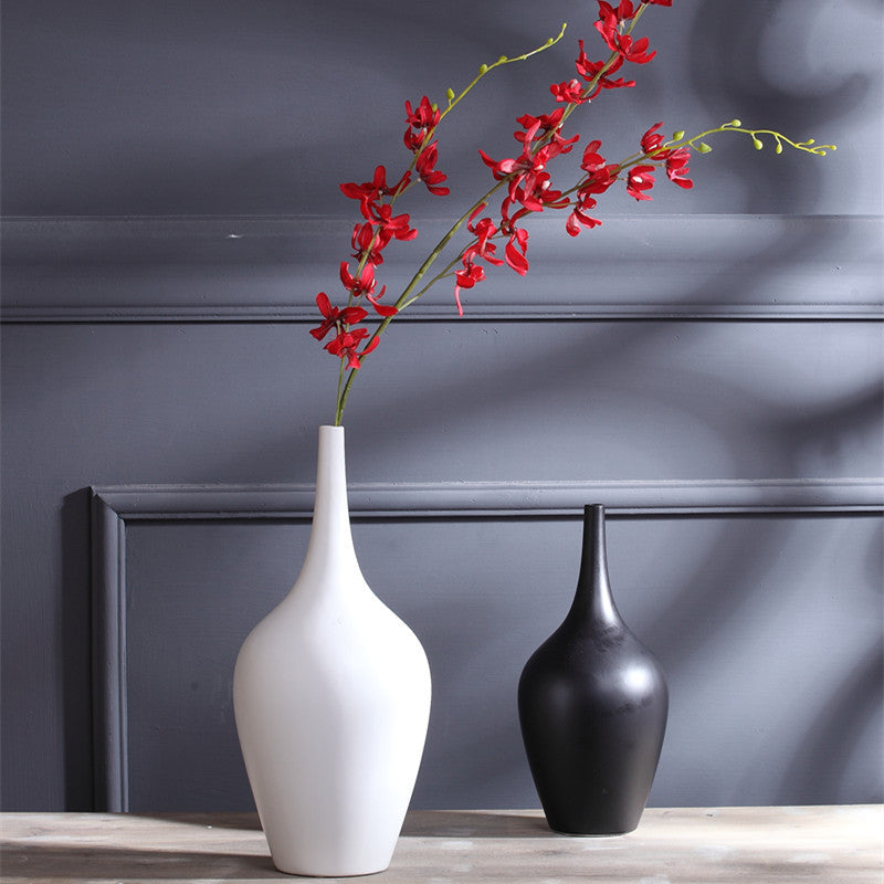 Matte ceramic teardrop vases in white and black with red flowers