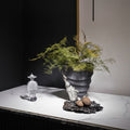 Styled matte charcoal vase with silver texture and greenery