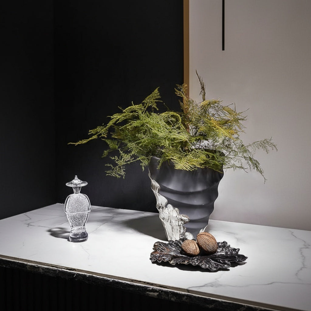 Styled matte charcoal vase with silver texture and greenery
