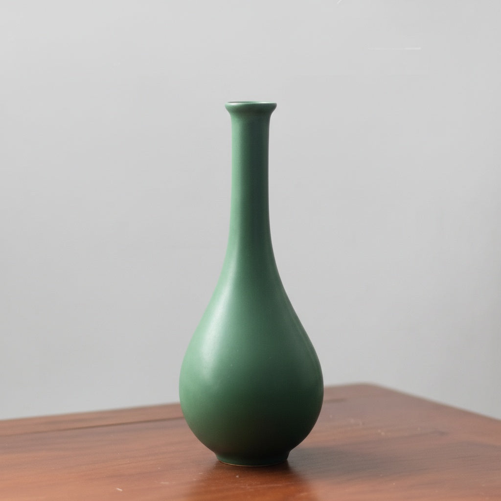Empty matte green ceramic vase showing slender neck and bulbous base
