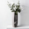 Abstract face vase with floral arrangement showing side profile