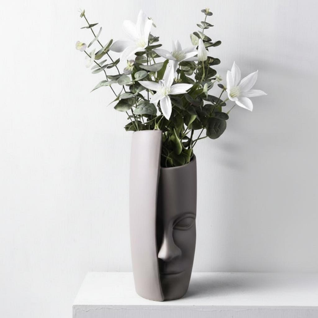 Abstract face vase with floral arrangement showing side profile
