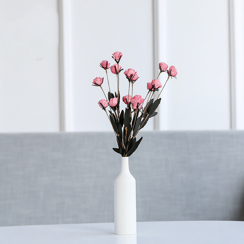 White vase with pink floral arrangement on grey background