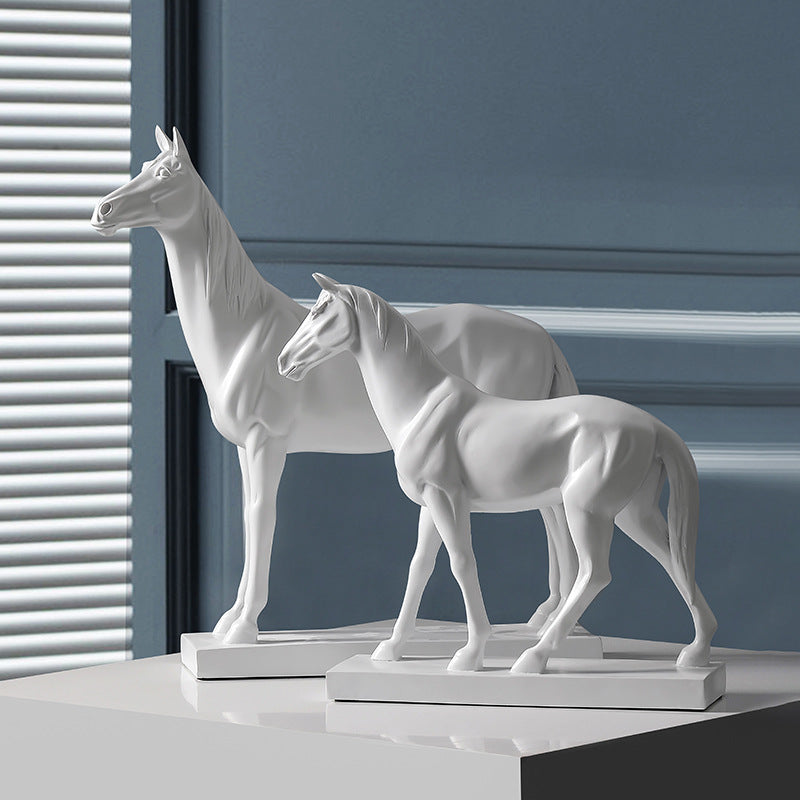 Two matte white horse sculptures standing on white surface