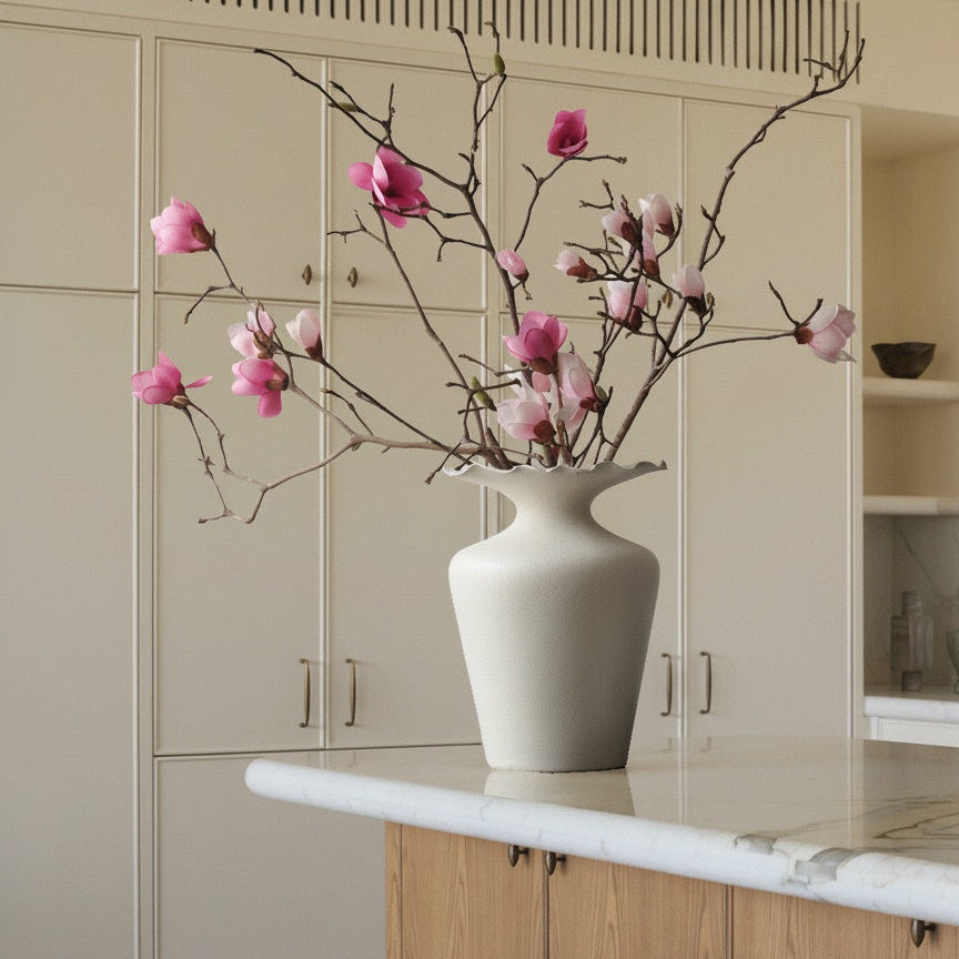 Matte white scalloped ceramic vase on a kitchen island