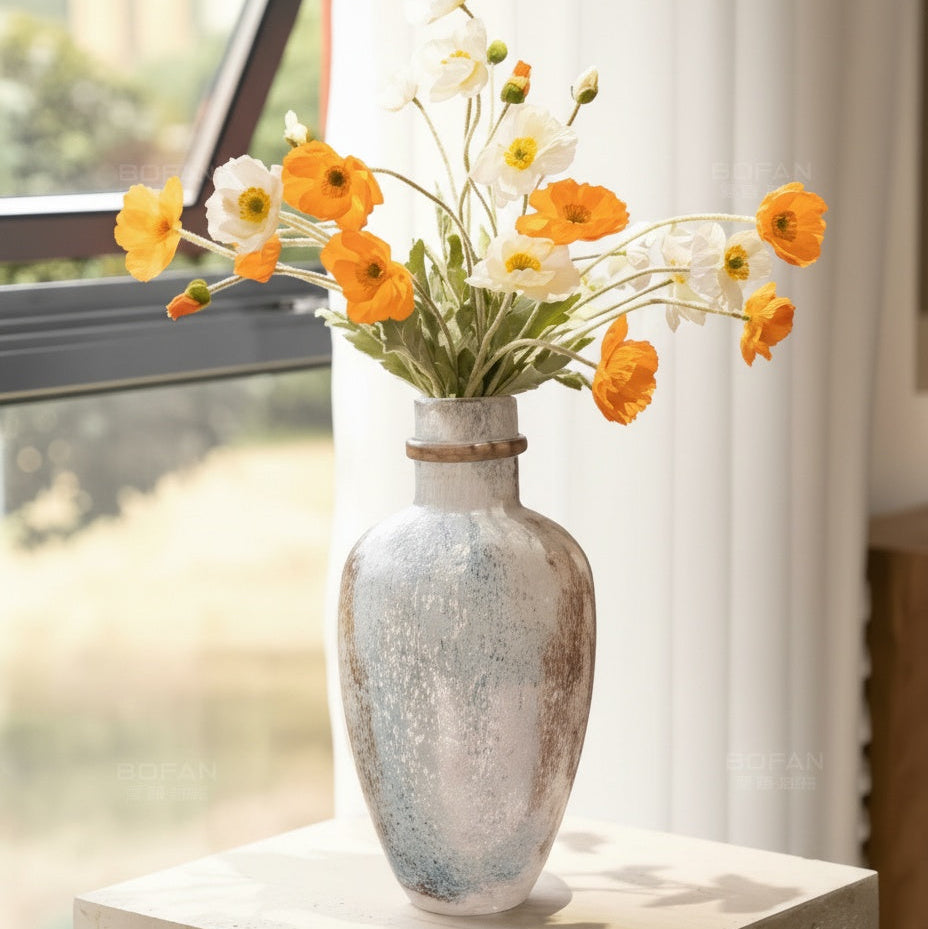 Lifestyle shot of mottled ceramic vase with yellow flowers
