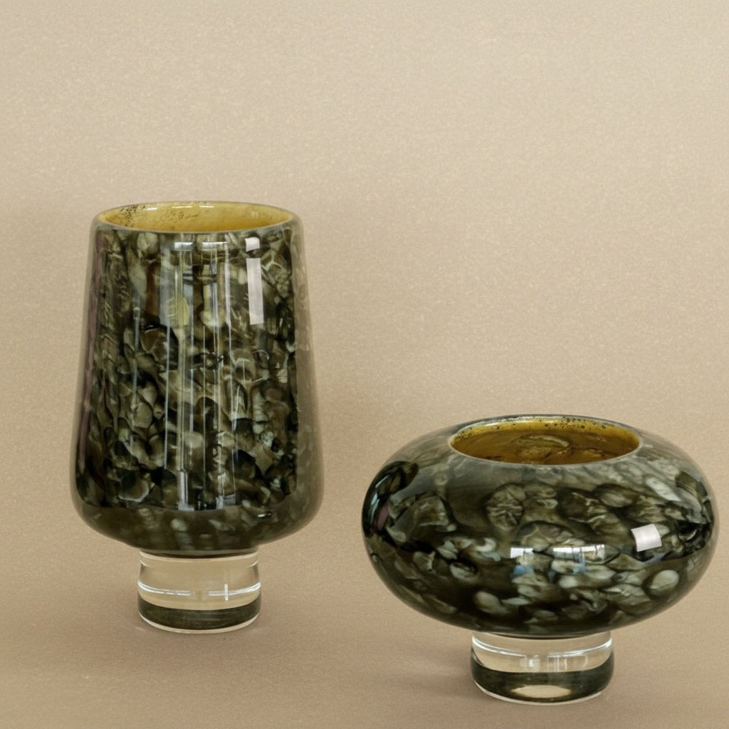 Mottled dark green art glass vase and bowl set on beige background