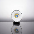 Front view of clear glass disc sculpture with blue and amber center on black base
