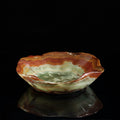 Side view of multi-color marble bowl with organic wavy rim on black background