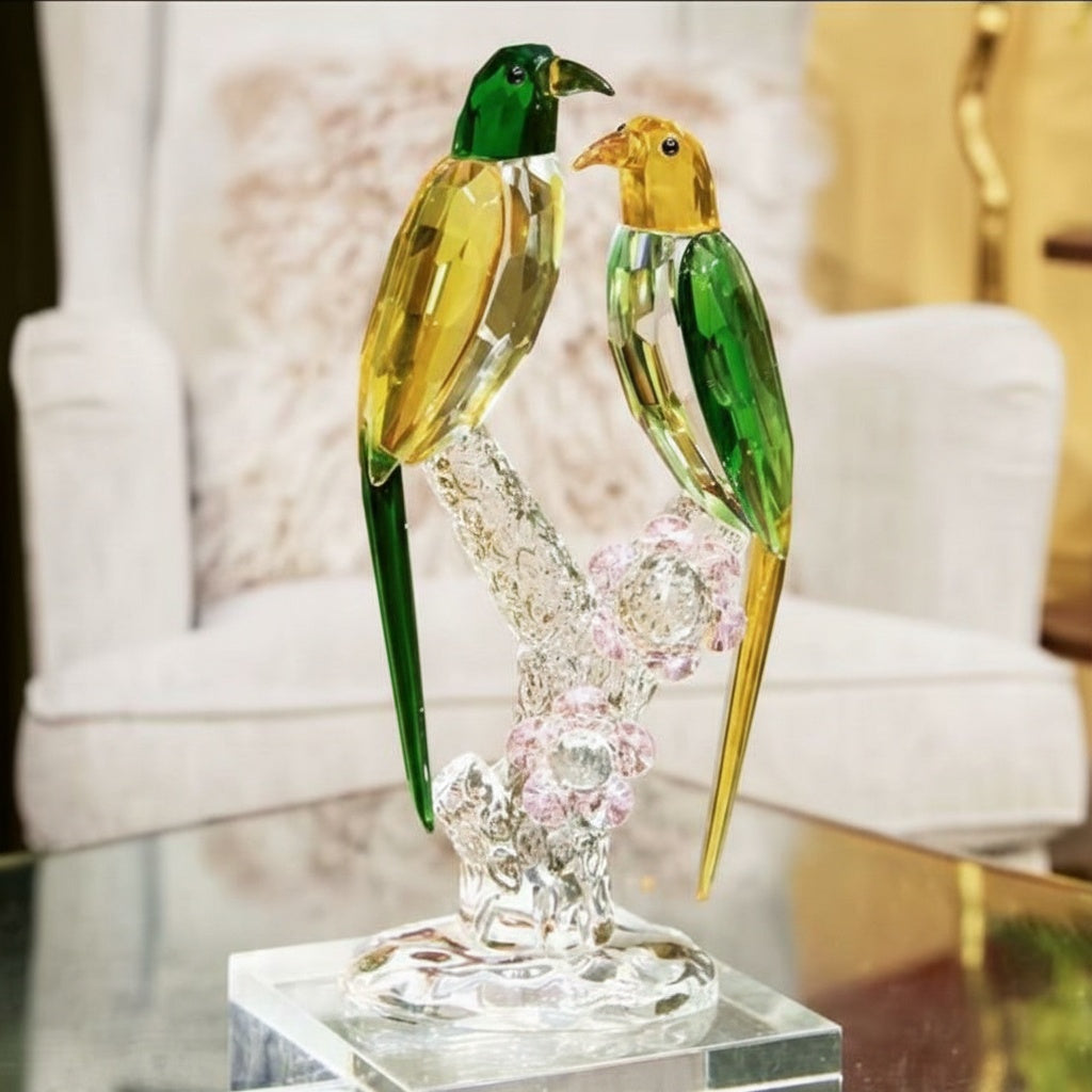 Front view of faceted crystal twin parrot sculpture on floral branch