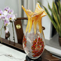 Front view of multicolor art glass fluted vase with amber rim and red patterns
