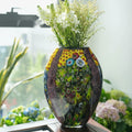 Multicolor art glass oval vase with flowers on window sill