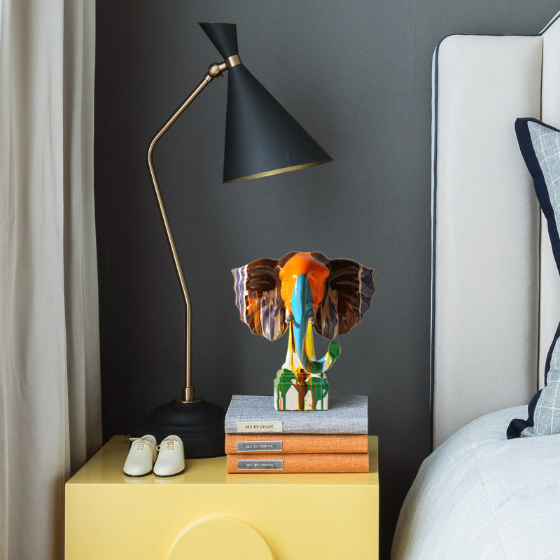 Medium elephant sculpture on a yellow bedside table