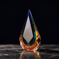 Front view of faceted glass teardrop sculpture in blue and amber