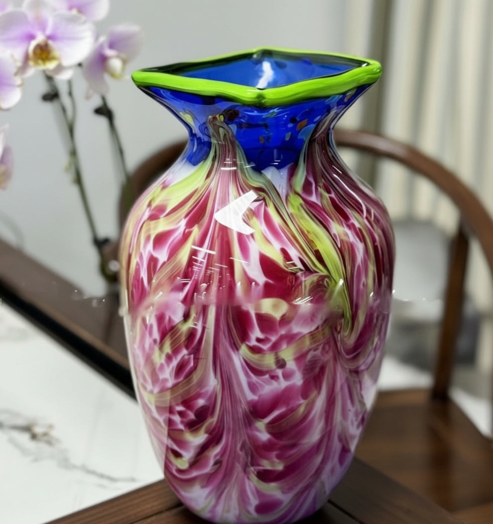 Side view of magenta and blue swirled glass vase