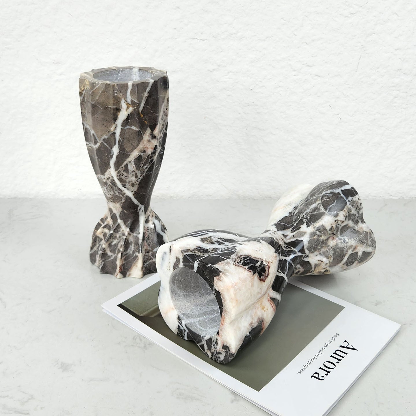 Marble candle holders displayed on table with magazine