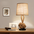 Natural rope table lamp with fabric shade on wooden table