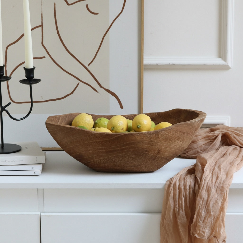Wooden bowl filled with lemons on white cabinet