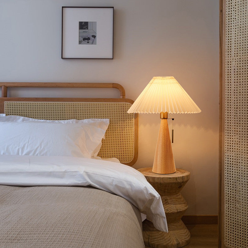 Wooden table lamp with pleated shade on bedside table lifestyle