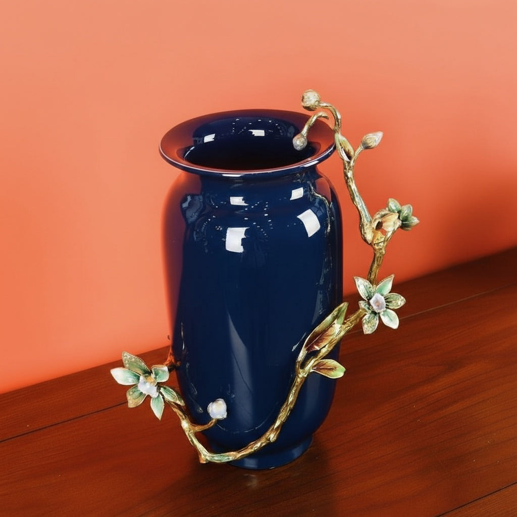 Front view of navy blue ceramic vase with brass floral branch