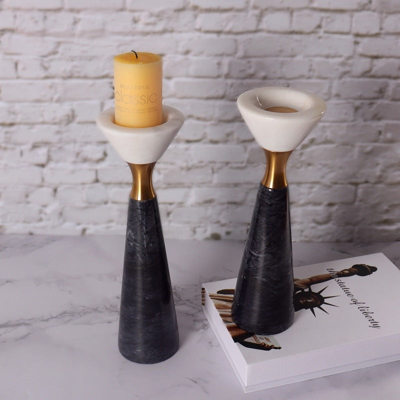 Styled marble candle holders with lit pillar candle on a book