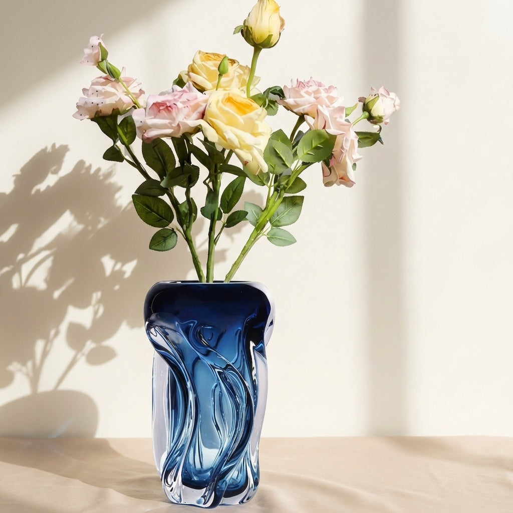 Medium blue glass wavy vase with roses in sunlight