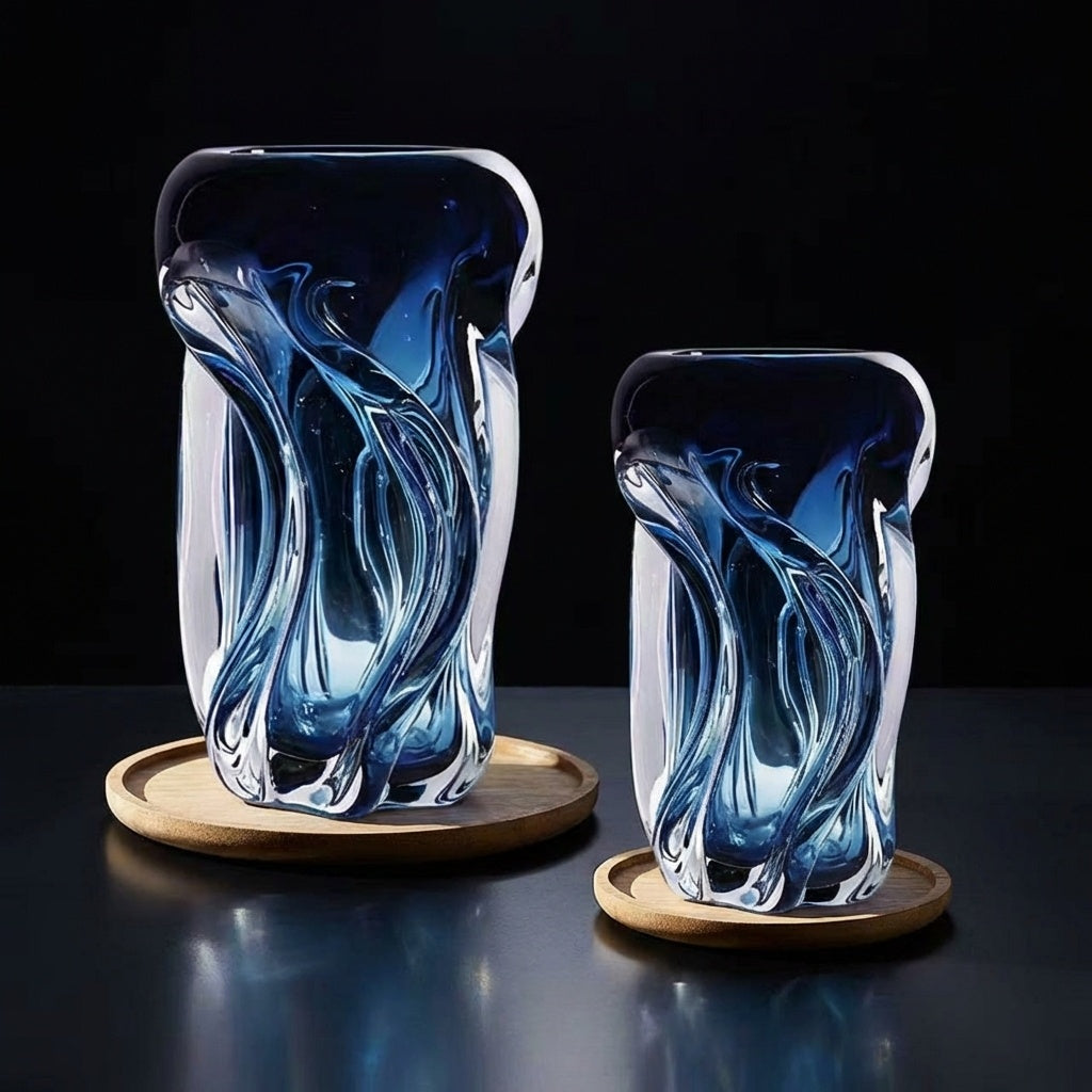 Two sculptural blue glass vases on wooden coasters