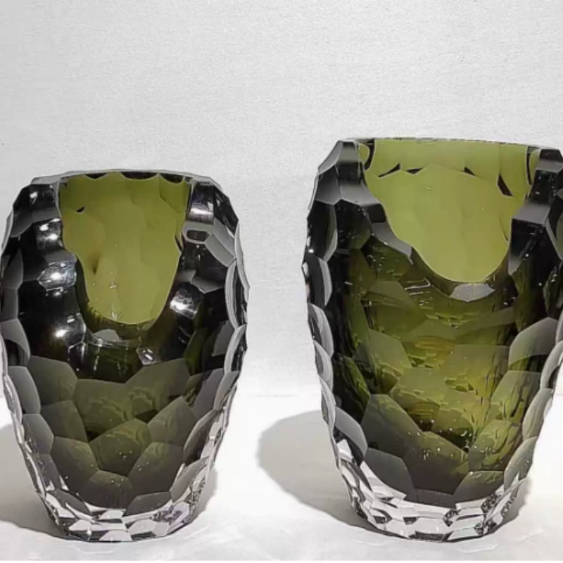 Two olive green geometric glass vases side by side