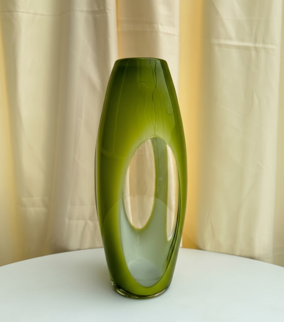Angled view of modern olive green glass vase