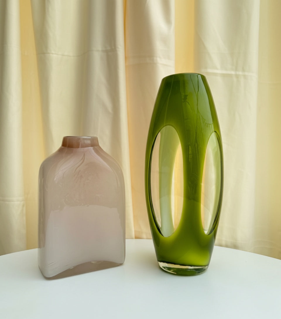 Olive green sculptural vase displayed next to smaller decor item