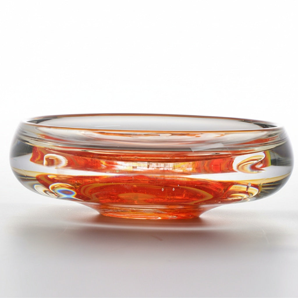 Side view of heavy clear and orange art glass bowl