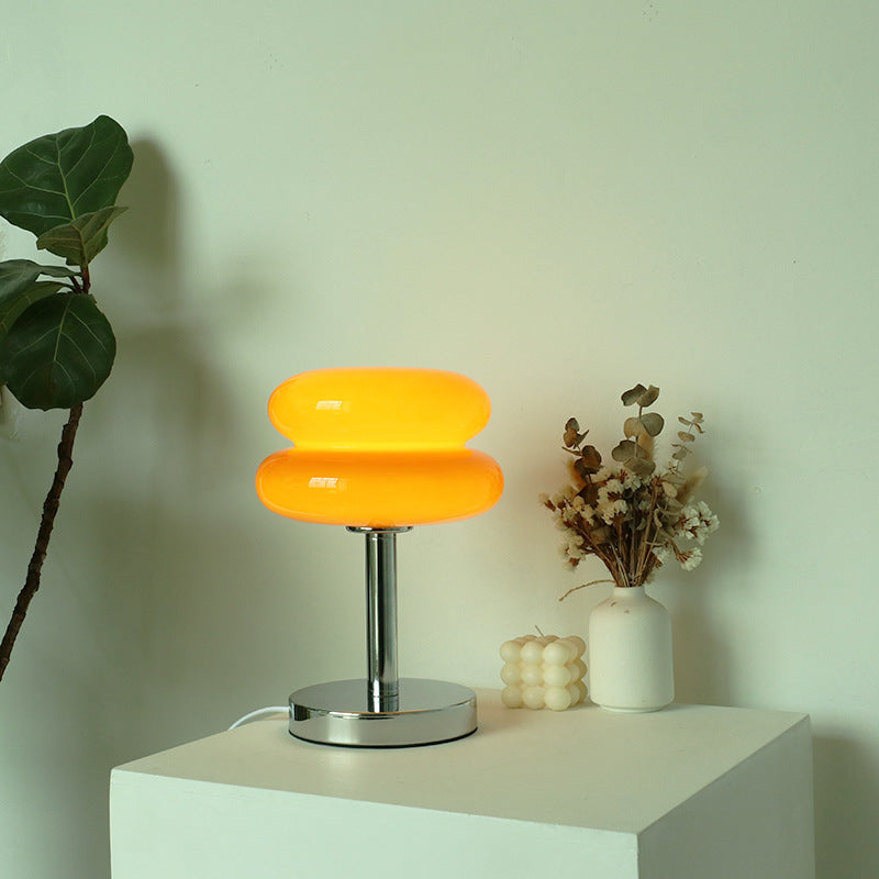Front view of orange glass mushroom lamp on white pedestal