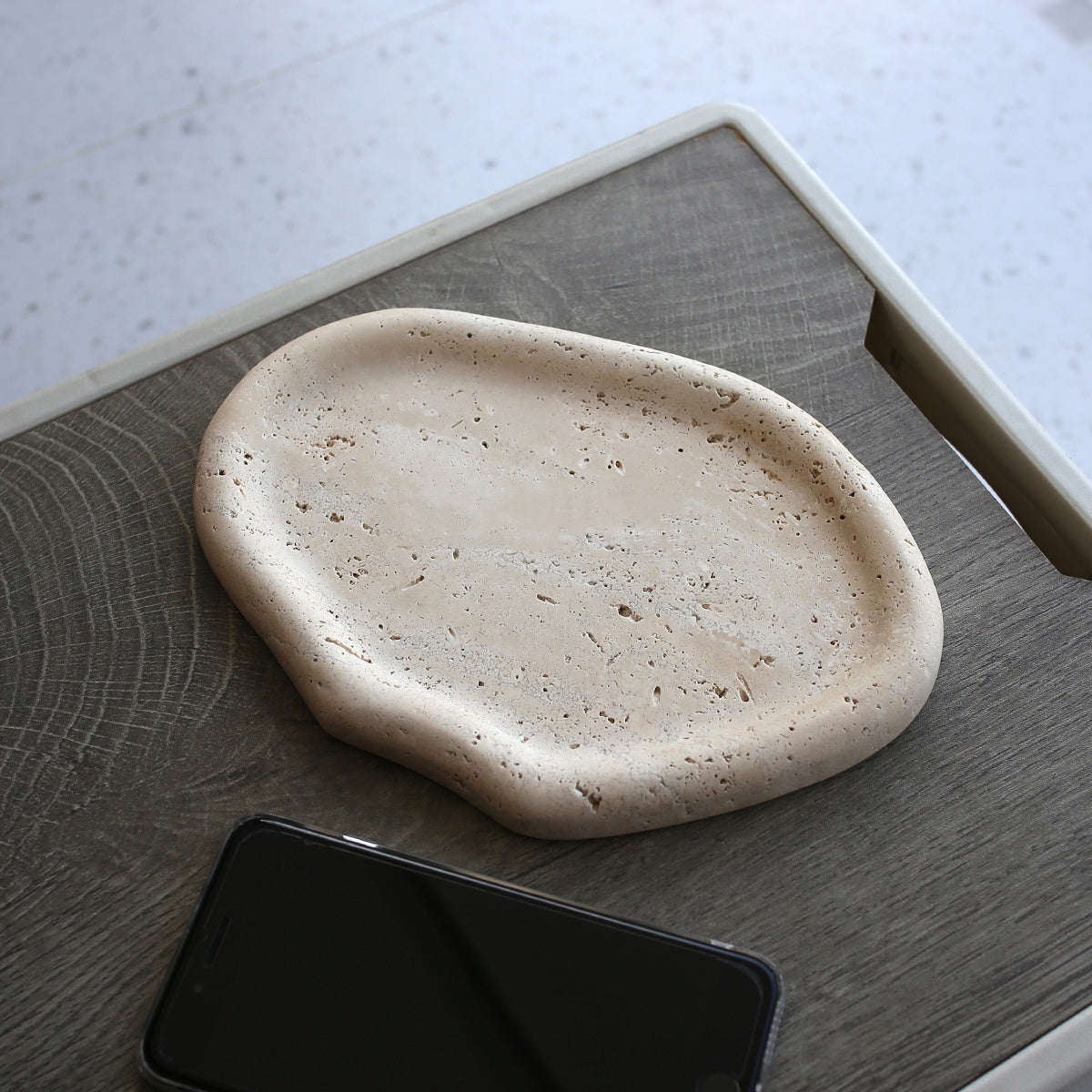 Beige organic travertine tray on textured surface