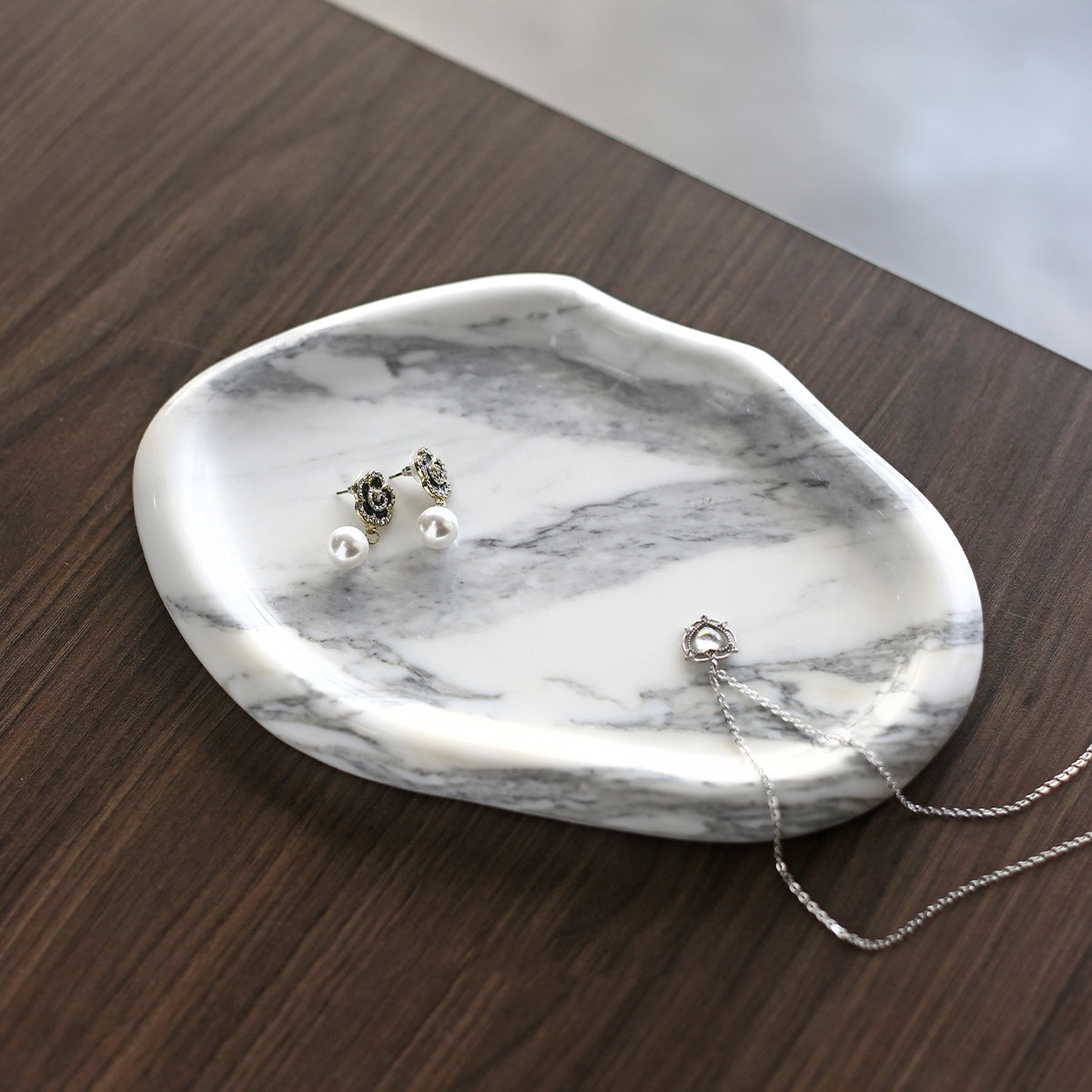 White Arabescato marble tray holding jewelry