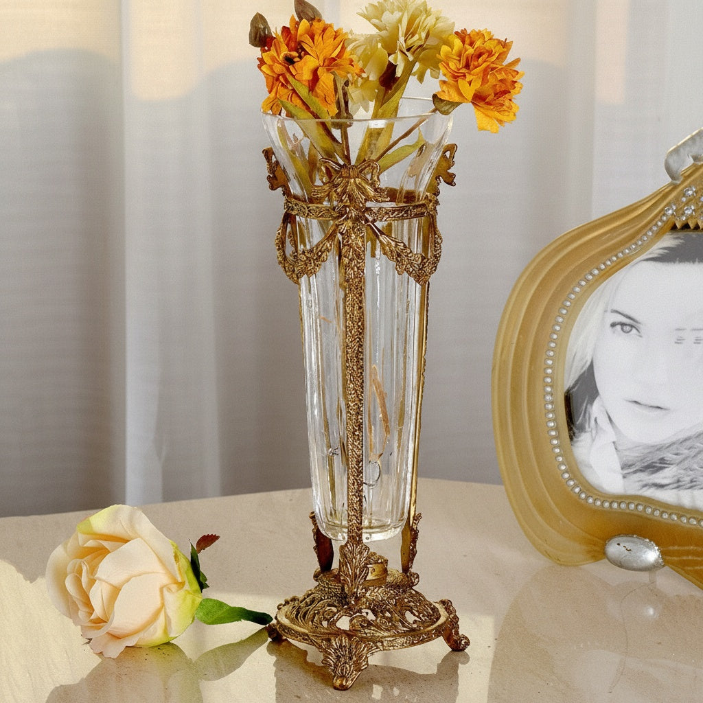 Ornate brass and glass flute vase with floral arrangement