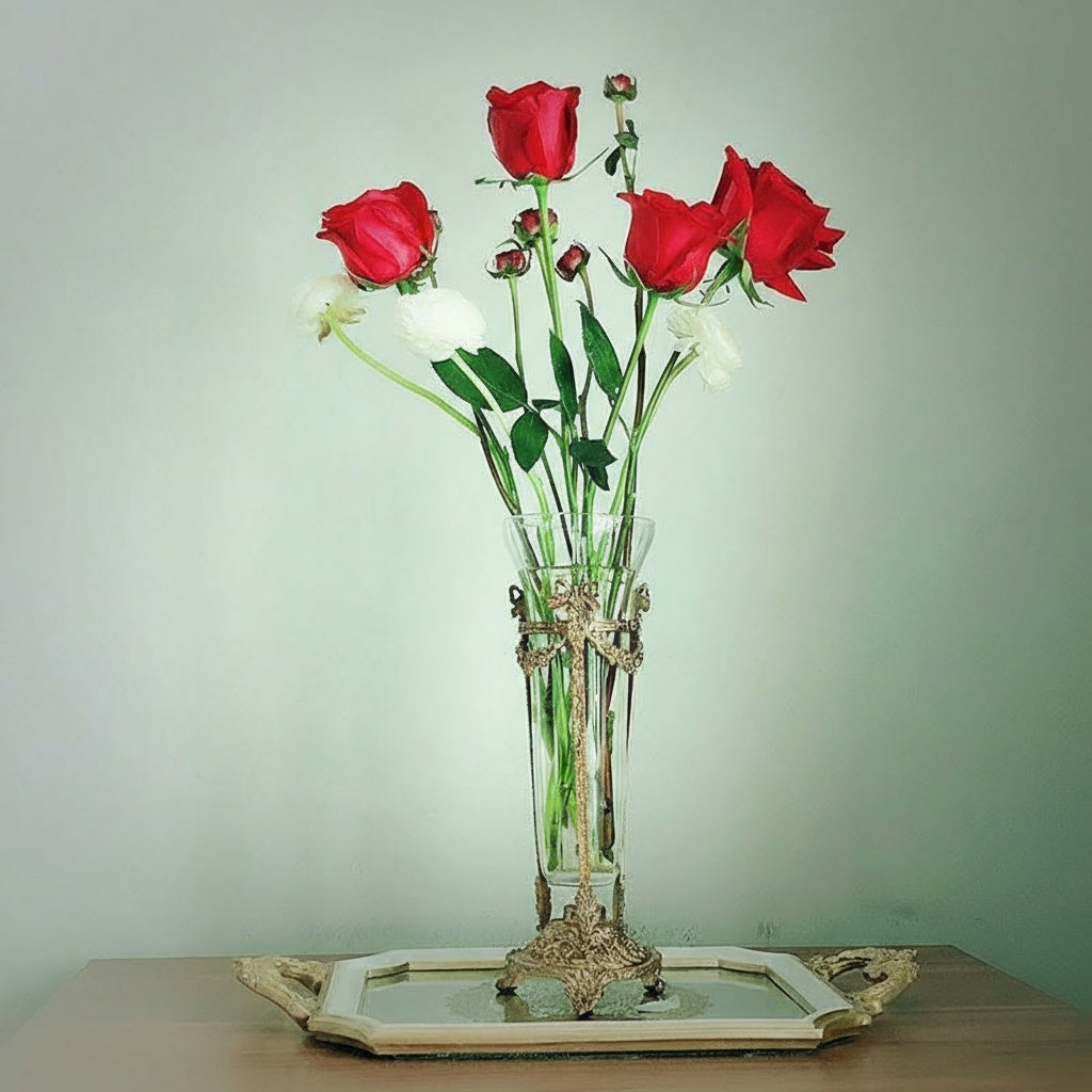 Ornate brass and glass flute vase holding red roses on a tray